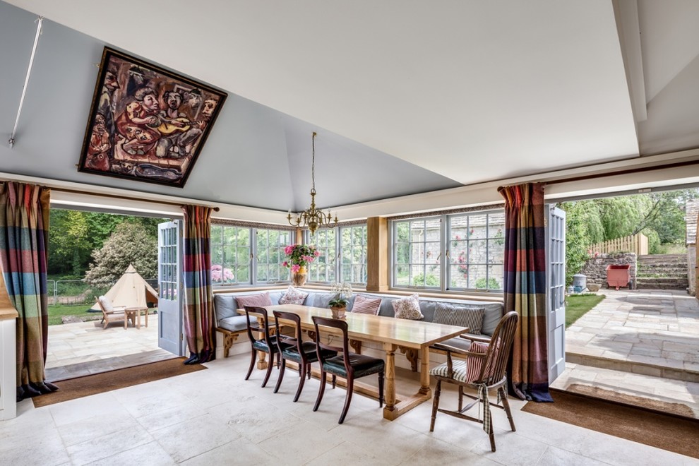 Ispirazione per una sala da pranzo aperta verso la cucina stile americano con pavimento in pietra calcarea e pavimento beige