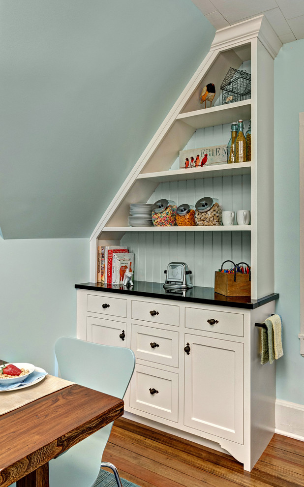 Idées déco pour une salle à manger ouverte sur la cuisine classique de taille moyenne avec un mur bleu et un sol en bois brun.