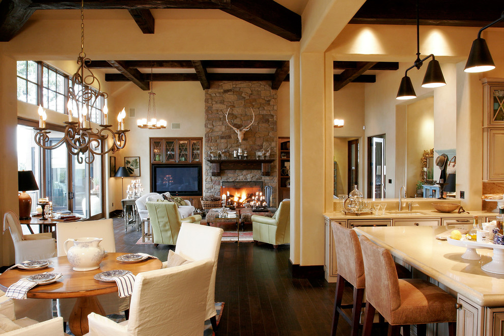 Idée de décoration pour une salle à manger ouverte sur le salon tradition avec un manteau de cheminée en pierre et éclairage.