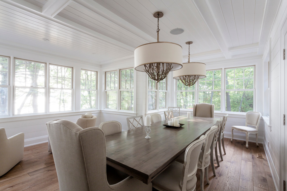 This is an example of a large traditional kitchen/dining room in Toronto with white walls and light hardwood flooring.