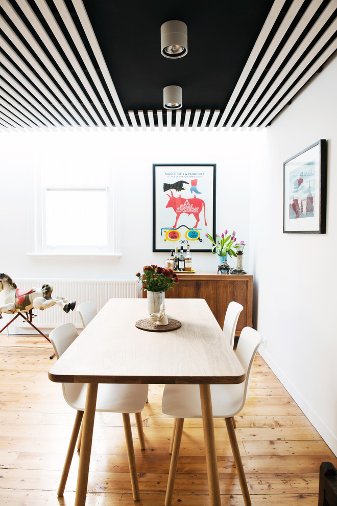 Inspiration for a mid-sized scandinavian medium tone wood floor great room remodel in Melbourne with white walls