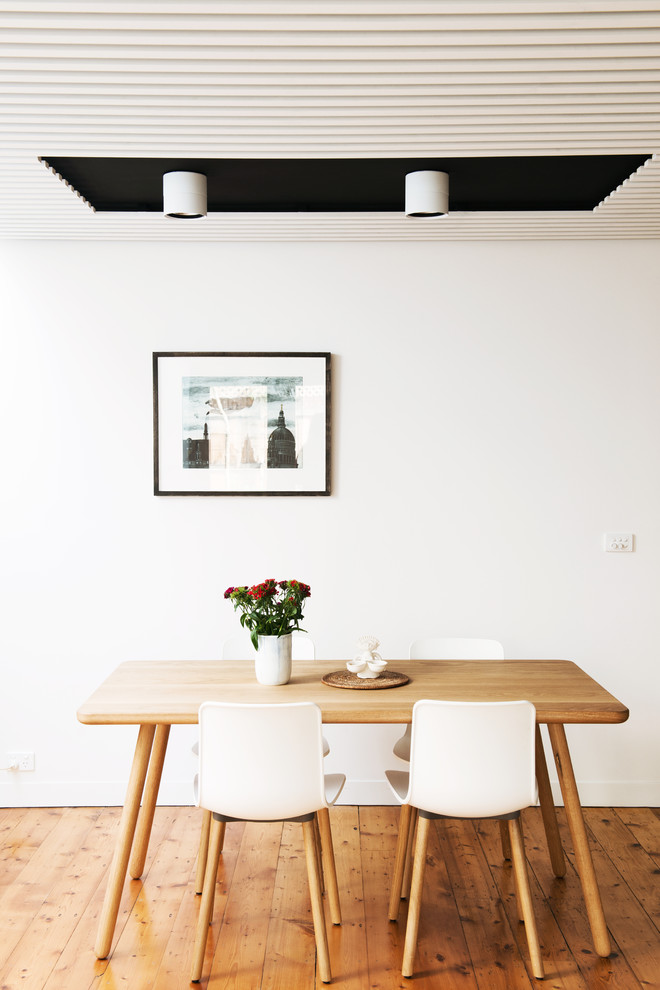 Imagen de comedor nórdico de tamaño medio abierto con paredes blancas y suelo de madera clara