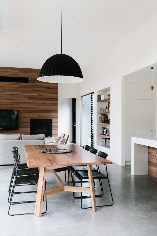 Ispirazione per una sala da pranzo aperta verso il soggiorno minimal di medie dimensioni con pareti bianche e pavimento in cemento