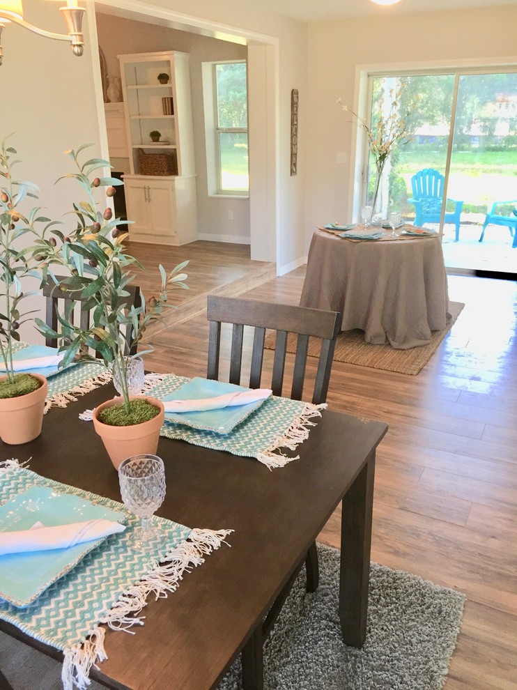 Esempio di una sala da pranzo aperta verso il soggiorno country di medie dimensioni con pareti beige, pavimento in legno massello medio e pavimento marrone