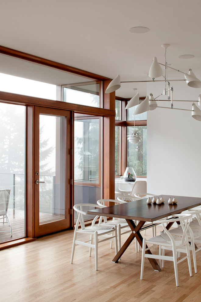 Imagen de comedor contemporáneo con paredes blancas, suelo de madera clara y suelo beige