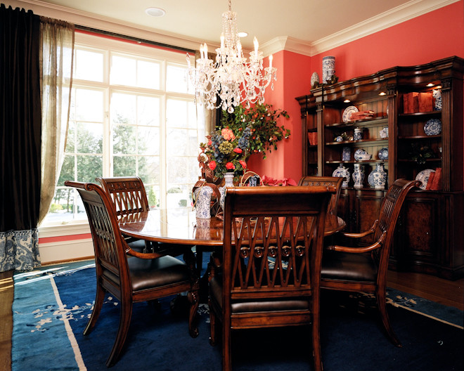 Mid-sized elegant medium tone wood floor enclosed dining room photo in Other with red walls