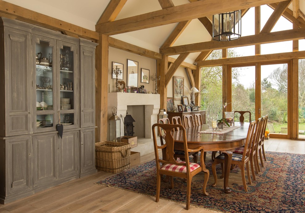 Diseño de comedor de estilo de casa de campo con paredes beige, estufa de leña y marco de chimenea de hormigón