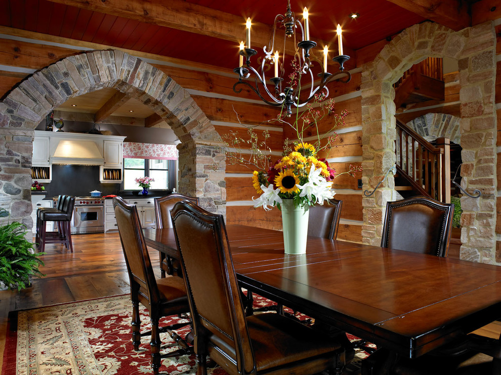 Foto di una grande sala da pranzo country chiusa con pareti marroni, pavimento in legno massello medio, nessun camino e pavimento marrone