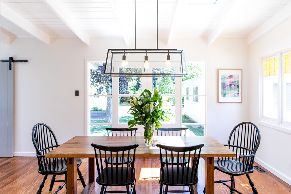 Ispirazione per una sala da pranzo aperta verso la cucina classica di medie dimensioni con pareti bianche e pavimento in legno massello medio
