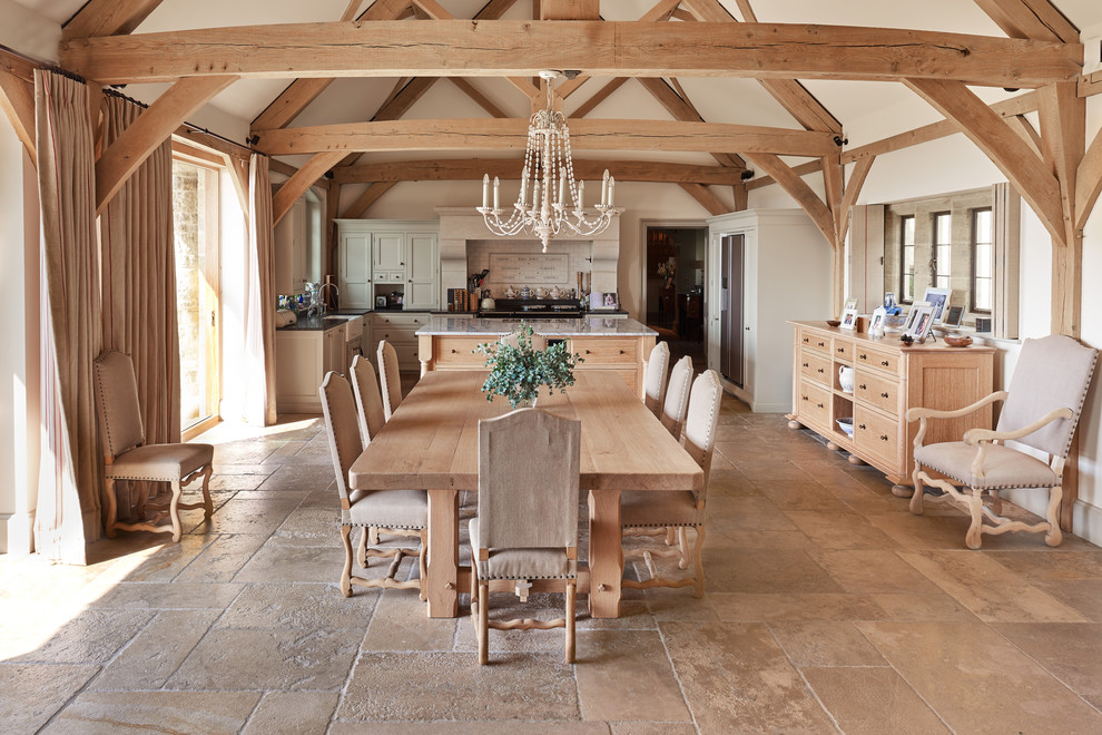 Immagine di una sala da pranzo aperta verso la cucina country con pareti bianche, nessun camino, pavimento beige e pavimento in pietra calcarea