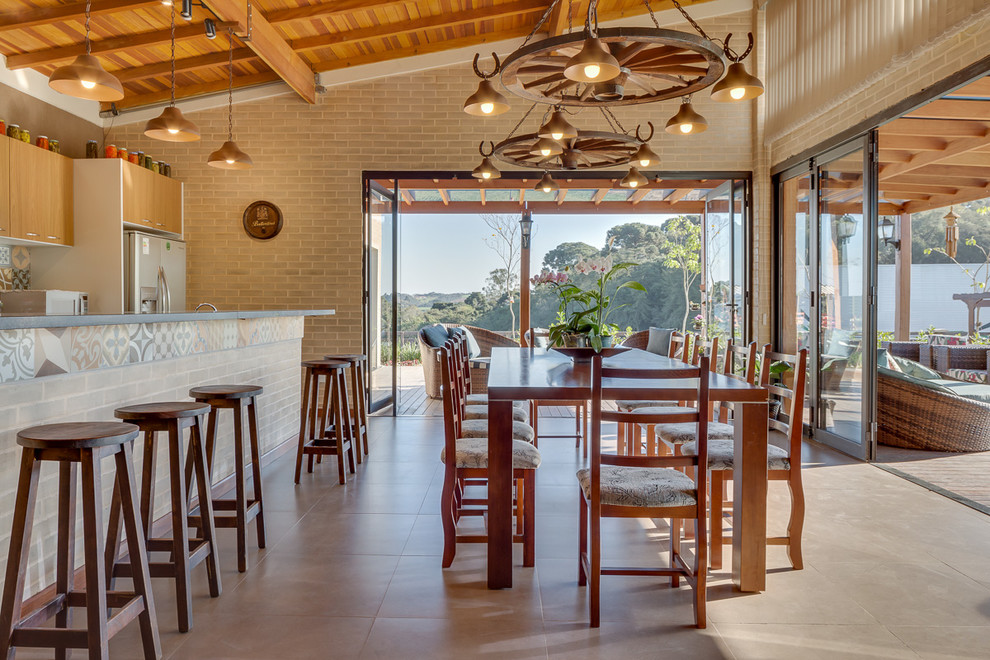 Foto di una sala da pranzo aperta verso la cucina country di medie dimensioni con pareti beige e pavimento in gres porcellanato