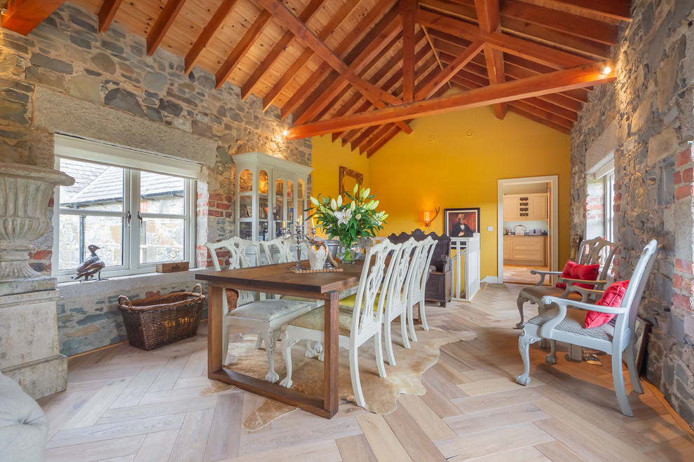 Inspiration pour une grande salle à manger ouverte sur le salon rustique avec un mur jaune, parquet clair et un sol beige.