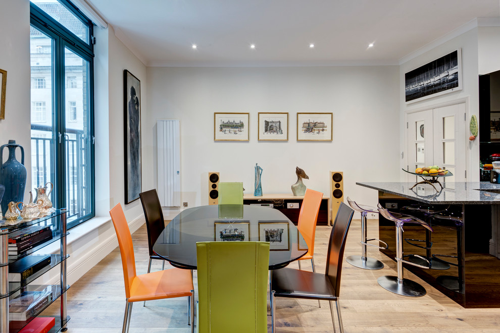 Immagine di una sala da pranzo aperta verso il soggiorno minimal di medie dimensioni con pareti bianche e parquet chiaro