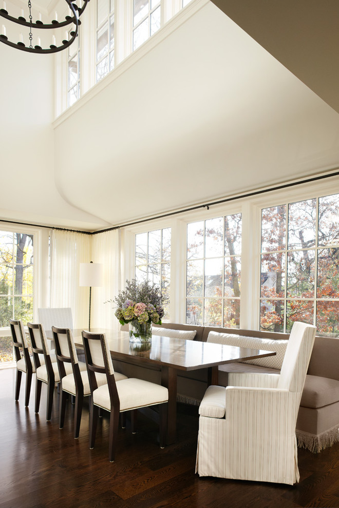 Aménagement d'une salle à manger classique avec un mur blanc, parquet foncé et éclairage.