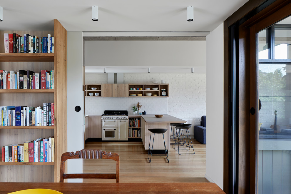 Ejemplo de comedor contemporáneo de tamaño medio abierto con paredes blancas y suelo de madera en tonos medios