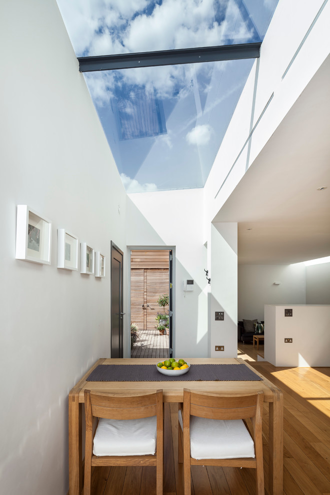 Modernes Esszimmer mit weißer Wandfarbe und hellem Holzboden in London