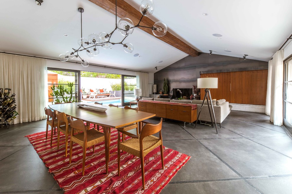 Immagine di una sala da pranzo aperta verso il soggiorno moderna con pareti bianche, pavimento in cemento e pavimento grigio