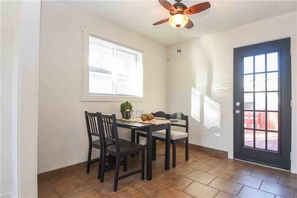 Foto på ett litet lantligt kök med matplats, med vita väggar, klinkergolv i keramik och brunt golv