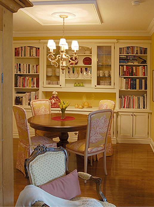 Foto di una piccola sala da pranzo chic con pareti gialle e pavimento in legno massello medio
