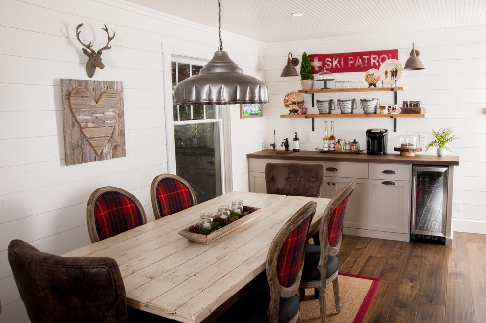 Idee per una sala da pranzo aperta verso la cucina stile rurale con parquet scuro, pareti bianche e pavimento marrone