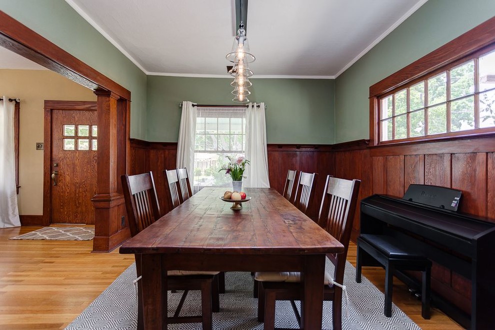 Immagine di una sala da pranzo stile americano chiusa e di medie dimensioni con pareti verdi, pavimento in legno massello medio, nessun camino e pavimento marrone