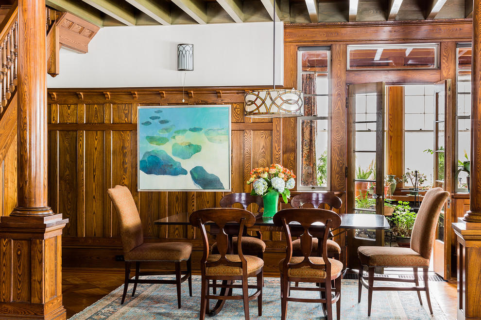 Aménagement d'une grande salle à manger ouverte sur le salon craftsman avec un sol en bois brun et un mur beige.