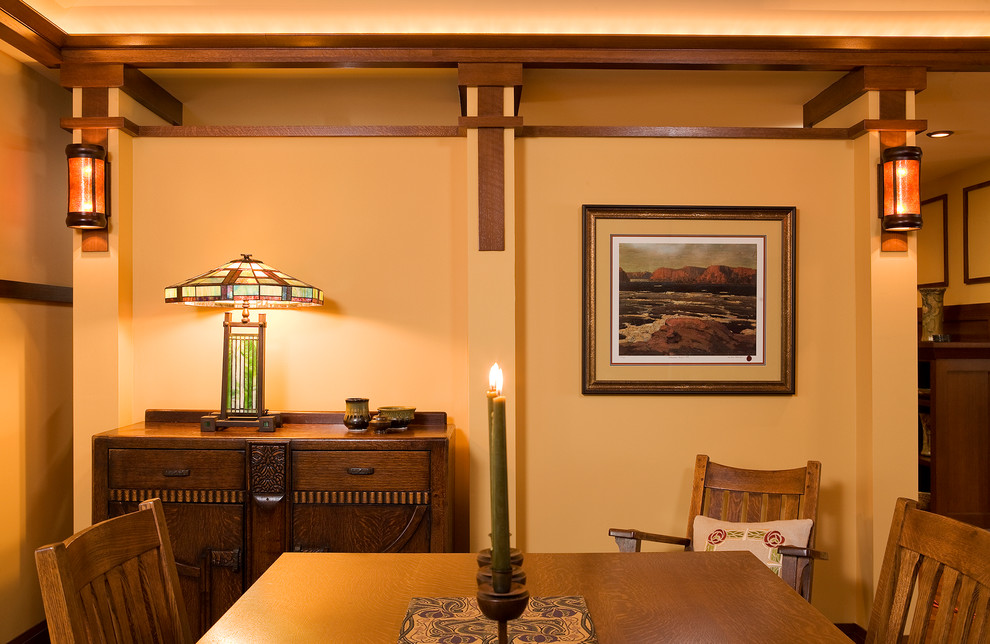 Cette image montre une salle à manger craftsman de taille moyenne avec un mur beige et un sol en bois brun.