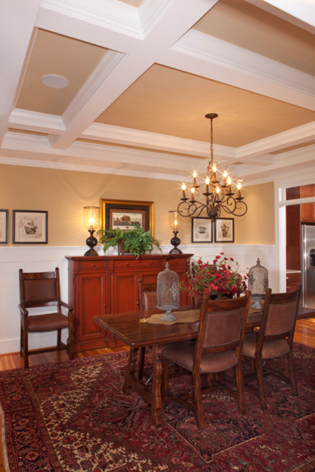 Cette image montre une salle à manger craftsman fermée et de taille moyenne avec un mur beige, un sol en bois brun et aucune cheminée.