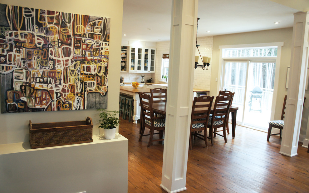 Immagine di una sala da pranzo aperta verso la cucina tradizionale di medie dimensioni con pareti verdi, pavimento in legno massello medio, camino classico e cornice del camino in pietra