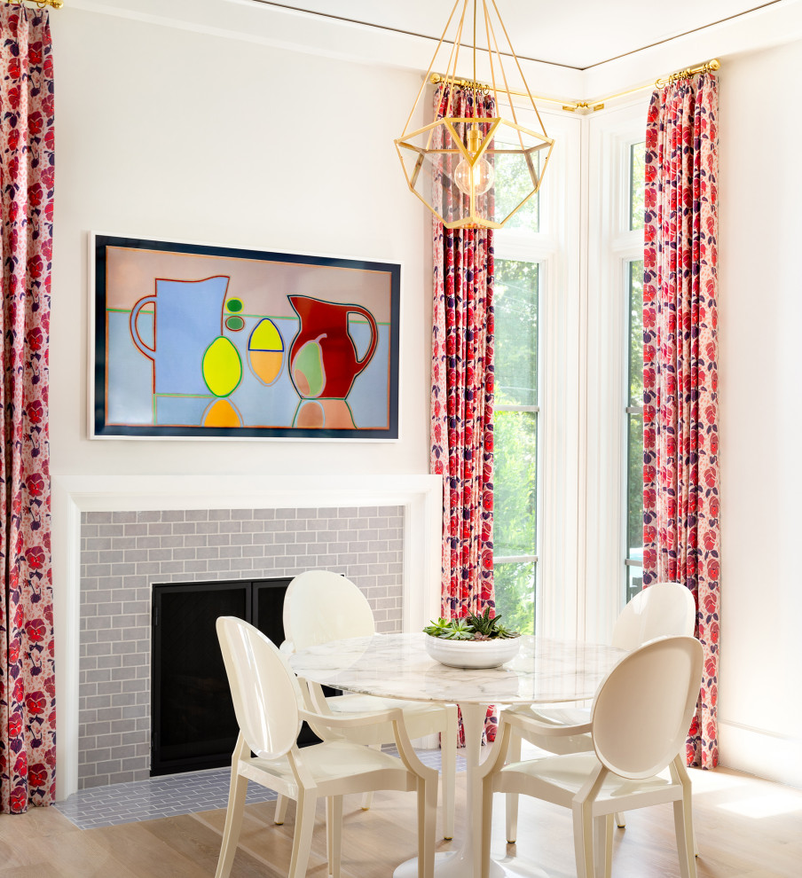 Inspiration pour une salle à manger traditionnelle avec un mur blanc, parquet clair, une cheminée standard et un manteau de cheminée en carrelage.