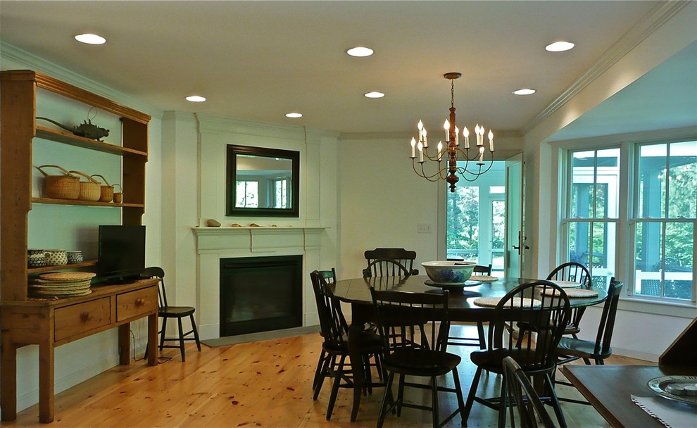 Große Rustikale Wohnküche mit Eckkamin, beiger Wandfarbe, braunem Holzboden, braunem Boden und Kaminumrandung aus Stein in Boston