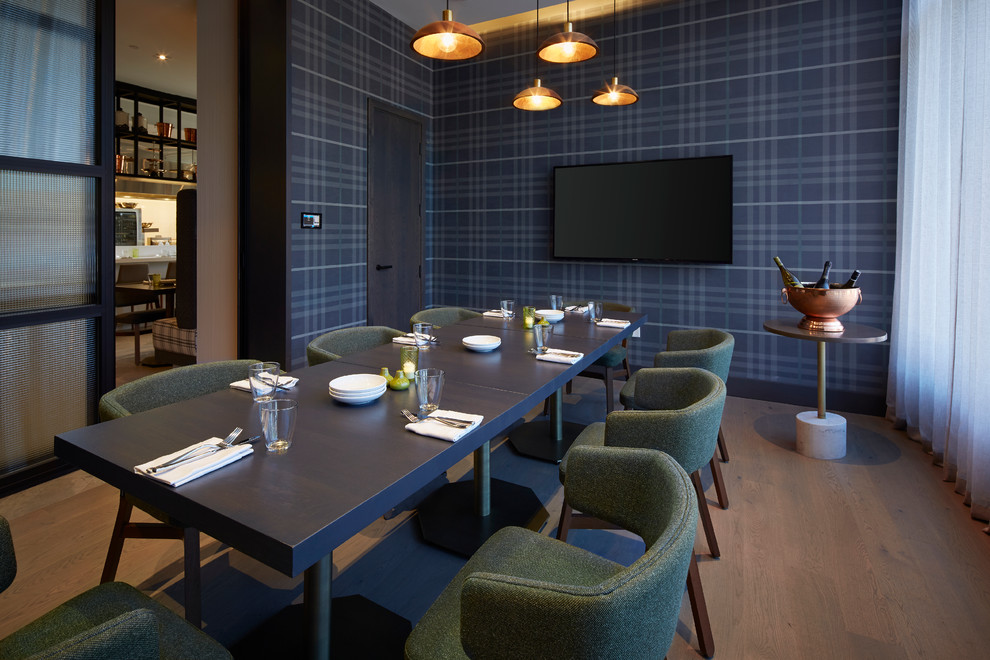 Immagine di una sala da pranzo aperta verso la cucina minimal con pavimento in legno massello medio