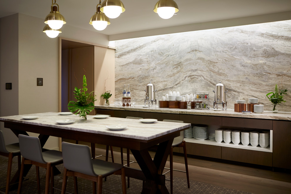 Idée de décoration pour une salle à manger ouverte sur la cuisine design avec un mur gris.