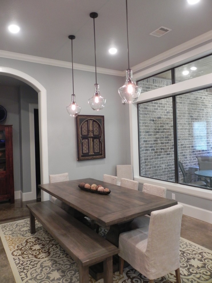 Example of an arts and crafts concrete floor dining room design in Houston with gray walls