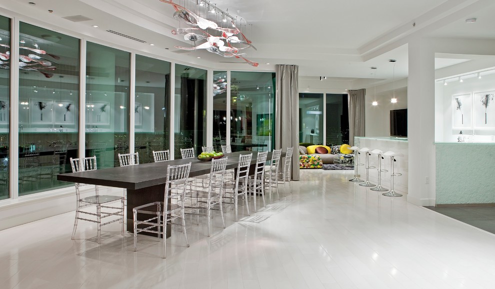 На фото: огромная кухня-столовая в стиле модернизм с белыми стенами, деревянным полом и белым полом без камина