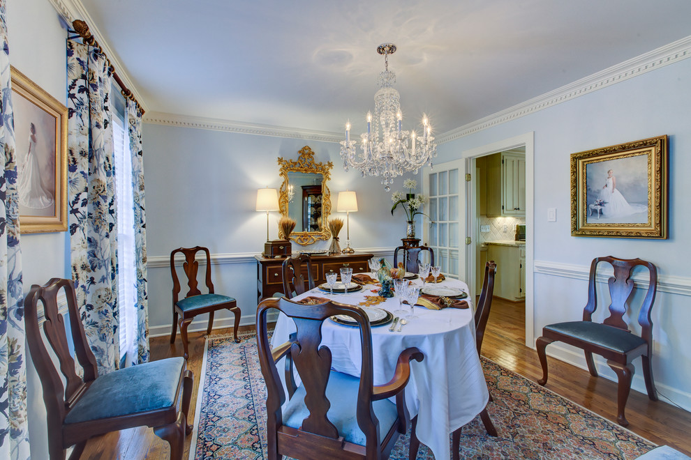 Ispirazione per una sala da pranzo tradizionale chiusa e di medie dimensioni con pareti blu, parquet chiaro e nessun camino