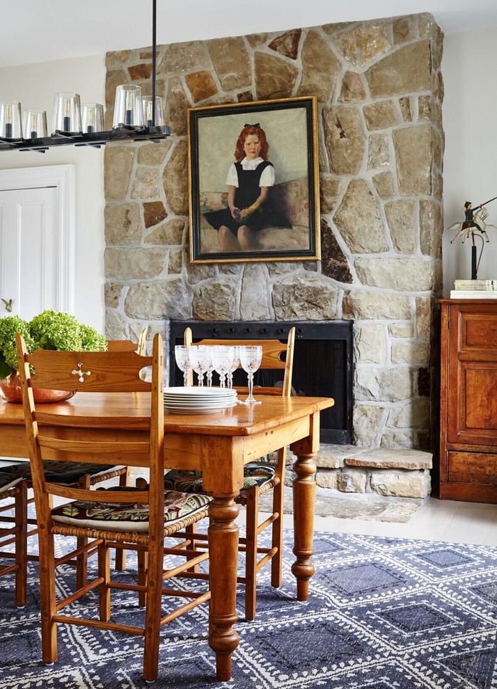 Ispirazione per una sala da pranzo tradizionale di medie dimensioni con pareti beige, parquet chiaro, camino classico e cornice del camino in pietra