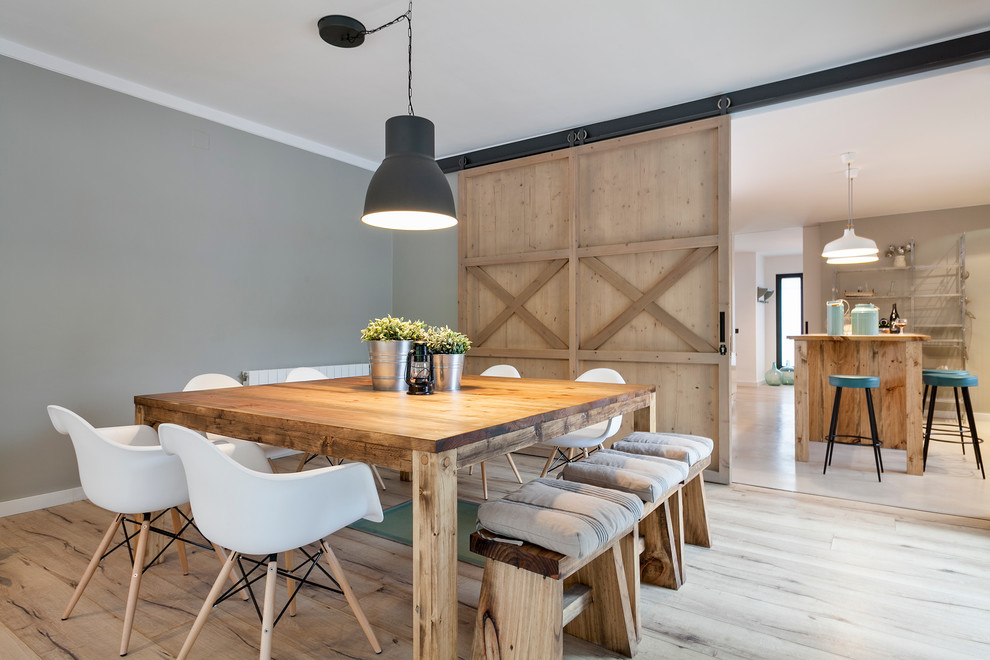 Diseño de comedor campestre grande cerrado sin chimenea con paredes grises y suelo de madera clara