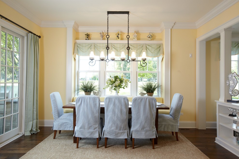 Inspiration for a timeless dark wood floor dining room remodel in Chicago with yellow walls