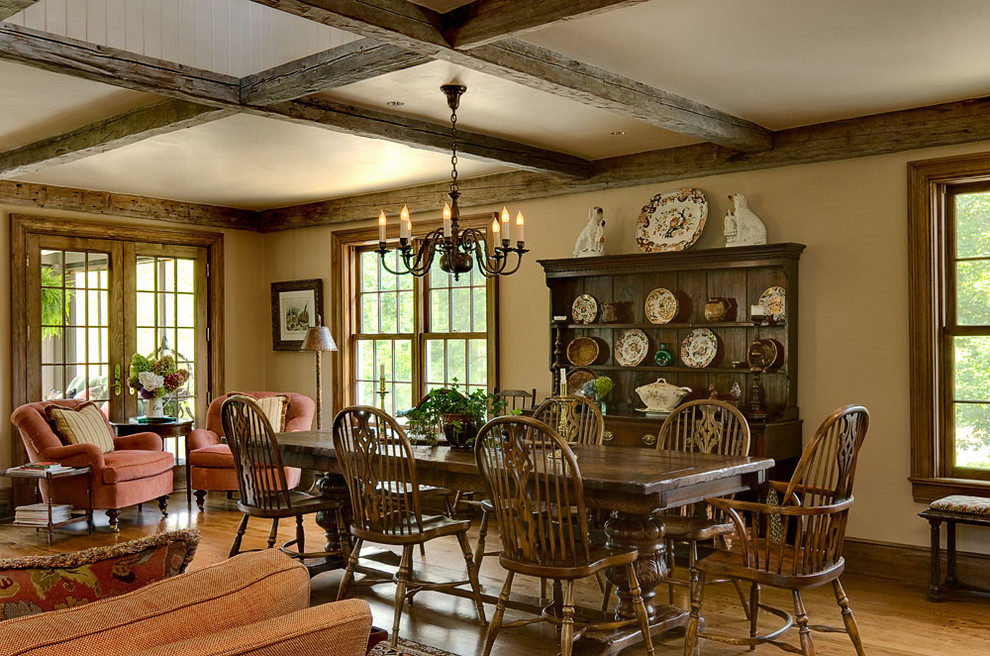 Aménagement d'une salle à manger classique avec un mur beige, un sol en bois brun et éclairage.