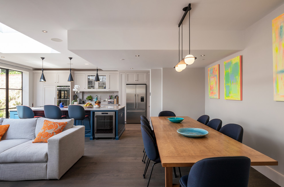 Cette image montre une salle à manger design avec un mur gris, parquet foncé et un sol marron.