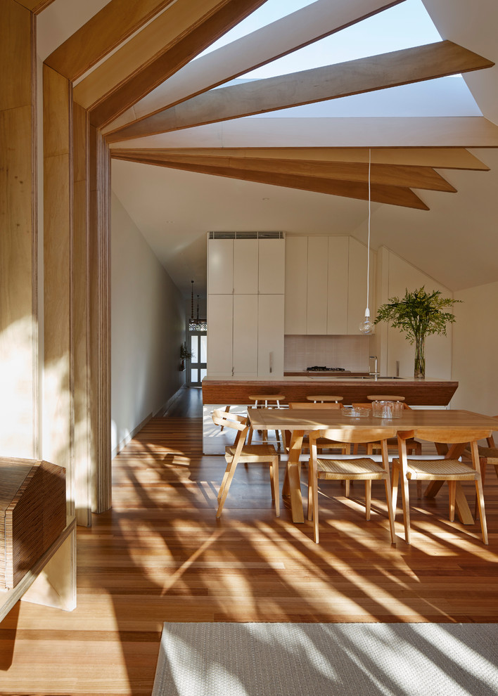 Diseño de comedor actual de tamaño medio abierto con paredes blancas y suelo de madera clara