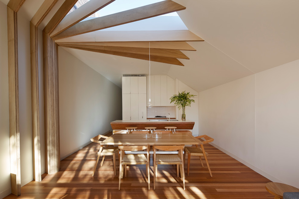 Foto de comedor actual de tamaño medio abierto con paredes blancas y suelo de madera en tonos medios