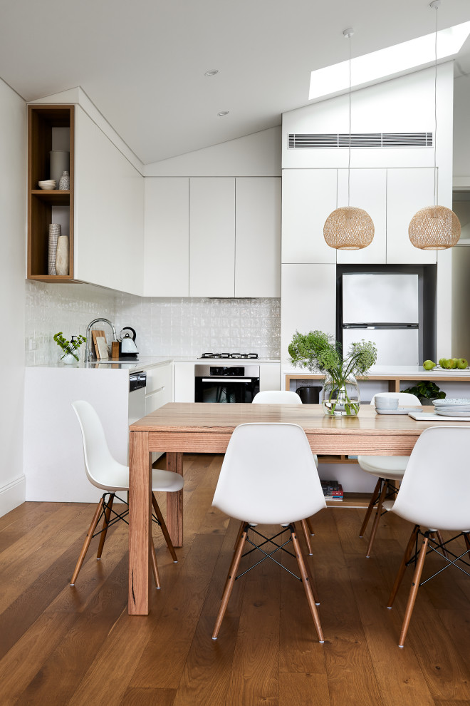 Inspiration för ett mellanstort funkis kök med matplats, med vita väggar, mellanmörkt trägolv och brunt golv