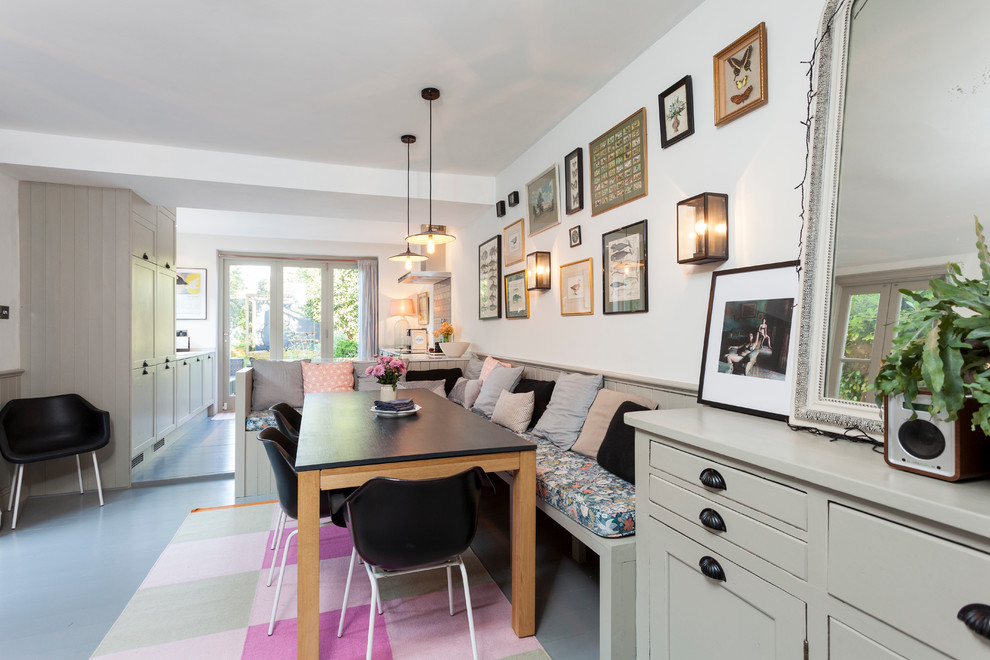 Dining room - scandinavian painted wood floor dining room idea in London with white walls
