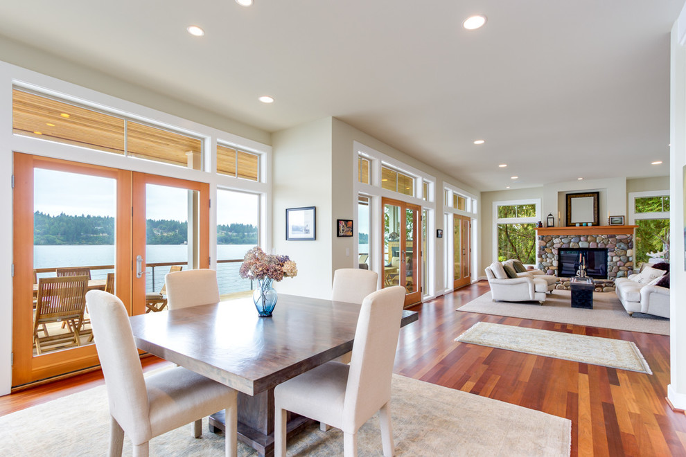 Foto di una grande sala da pranzo aperta verso il soggiorno stile marinaro con pareti beige e pavimento in legno massello medio