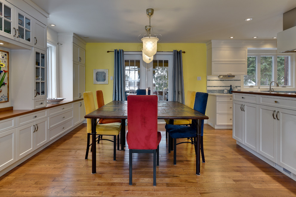 Mittelgroße Eklektische Wohnküche ohne Kamin mit gelber Wandfarbe, braunem Holzboden und braunem Boden in Montreal