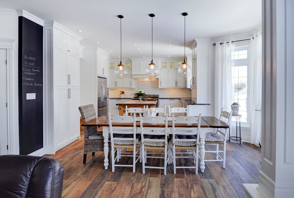 Foto di una sala da pranzo aperta verso il soggiorno chic con pavimento in legno massello medio