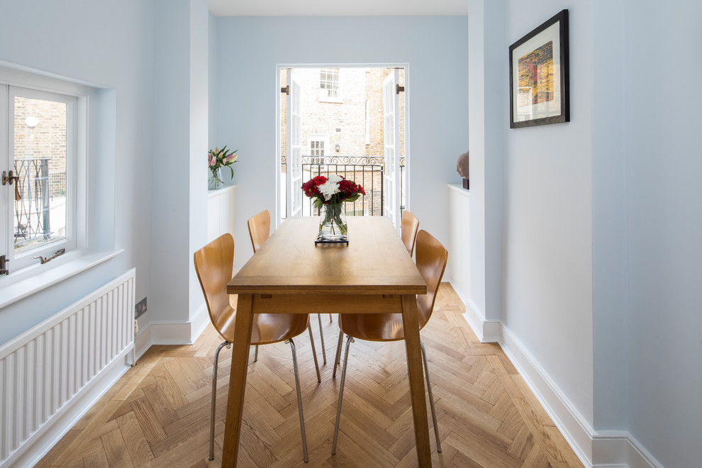 Cette image montre une salle à manger traditionnelle avec un mur bleu, parquet clair et aucune cheminée.