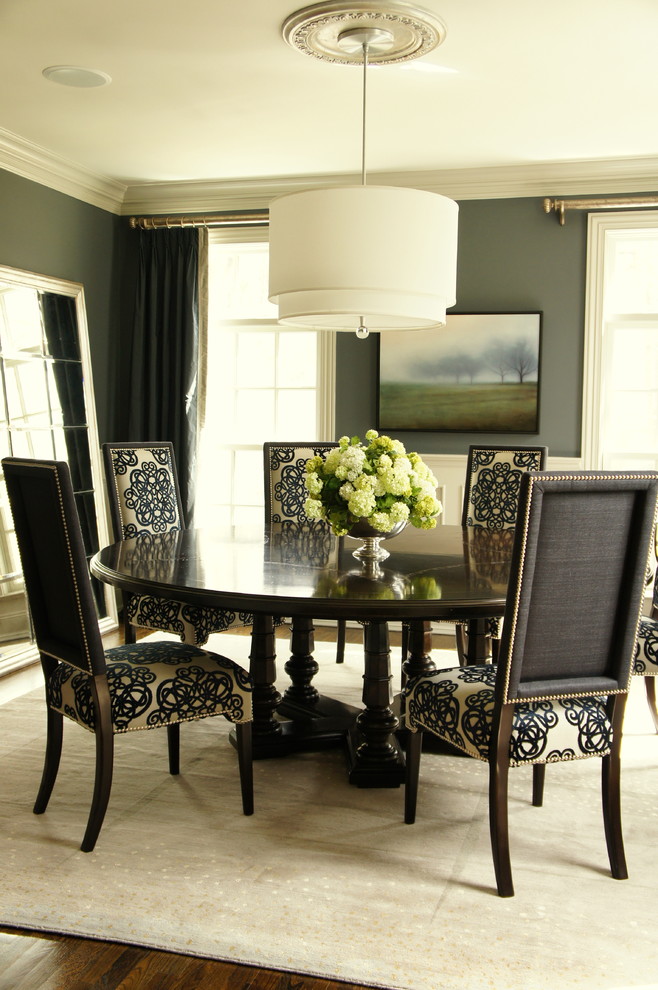 На фото: столовая в классическом стиле с серыми стенами и темным паркетным полом с